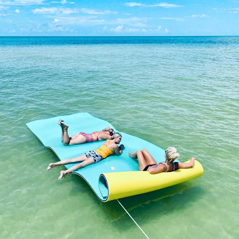 Group of 3 people lounging on an 18ft float mat