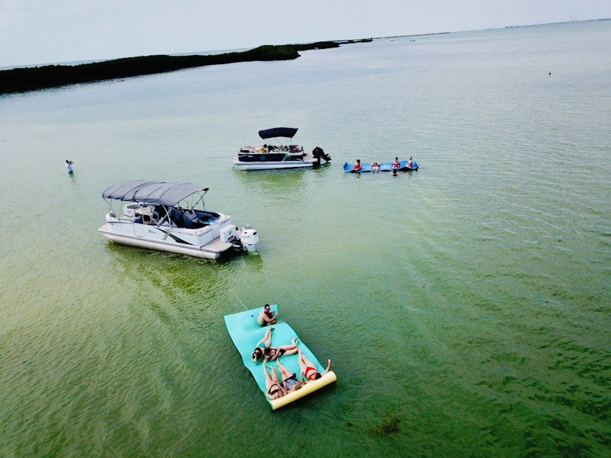 Two pontoons, two float mats, and people on both float mats