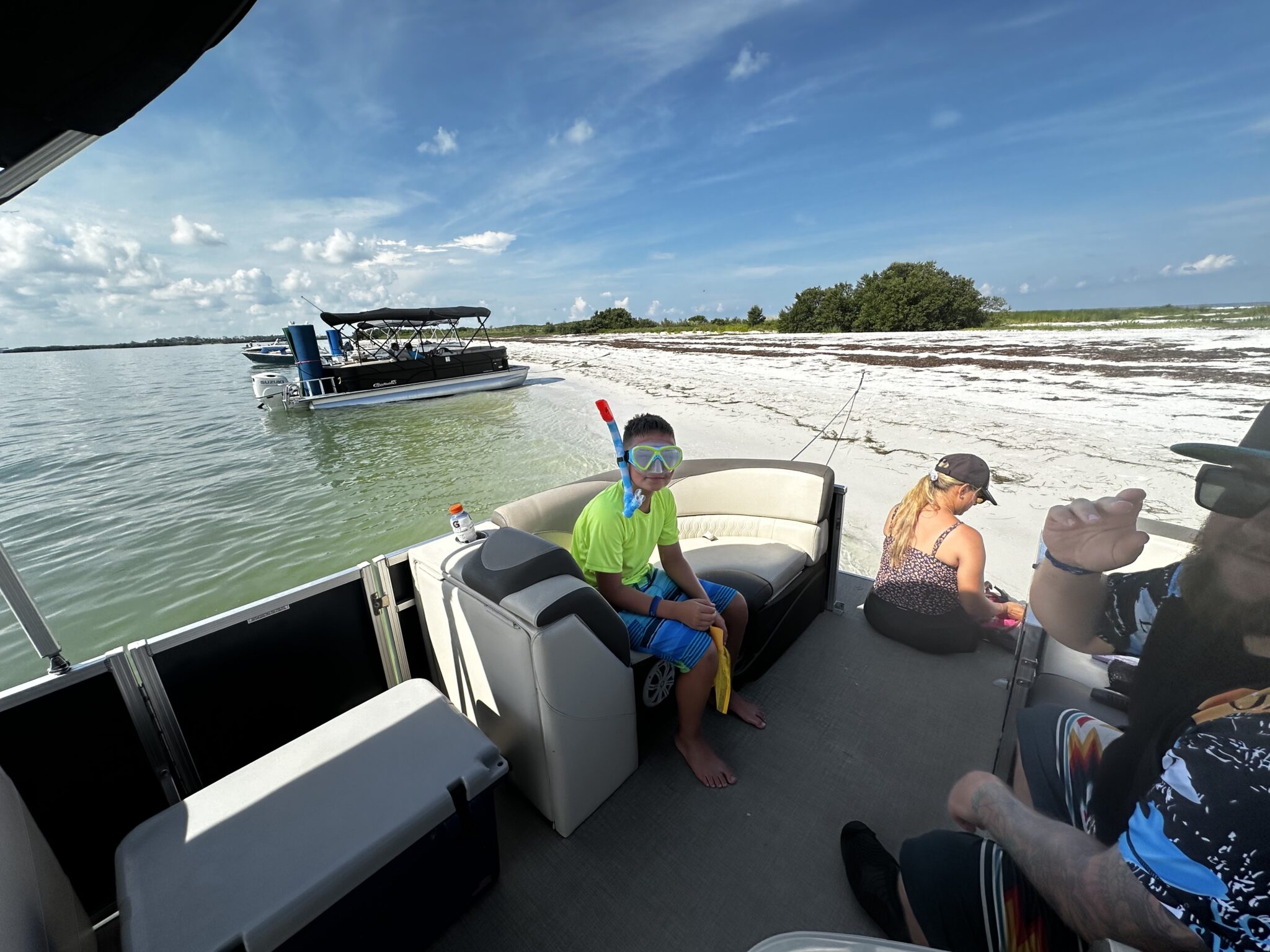 Pontoon boat ride at sandbar, kid on boat with snorkel gear