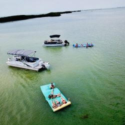 Two pontoons, two float mats, and people on both float mats