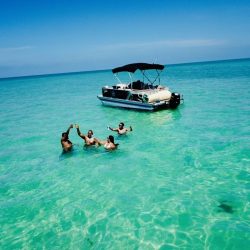 Pontoon with group of 4 people swimming beside it.