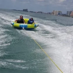 two people tubing with Clearwater Beach in the background
